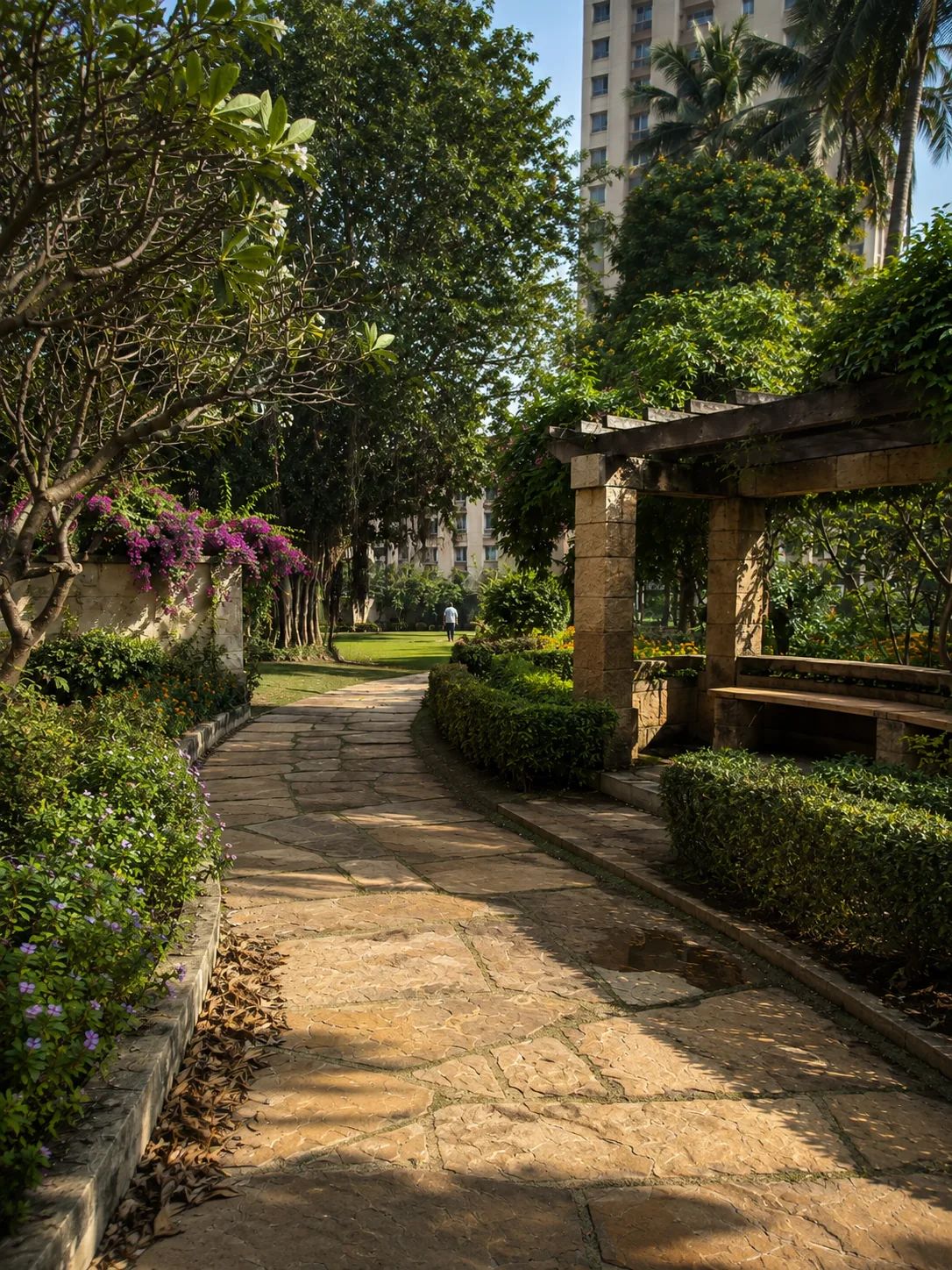 A stone path through the gardens, under the pergola.