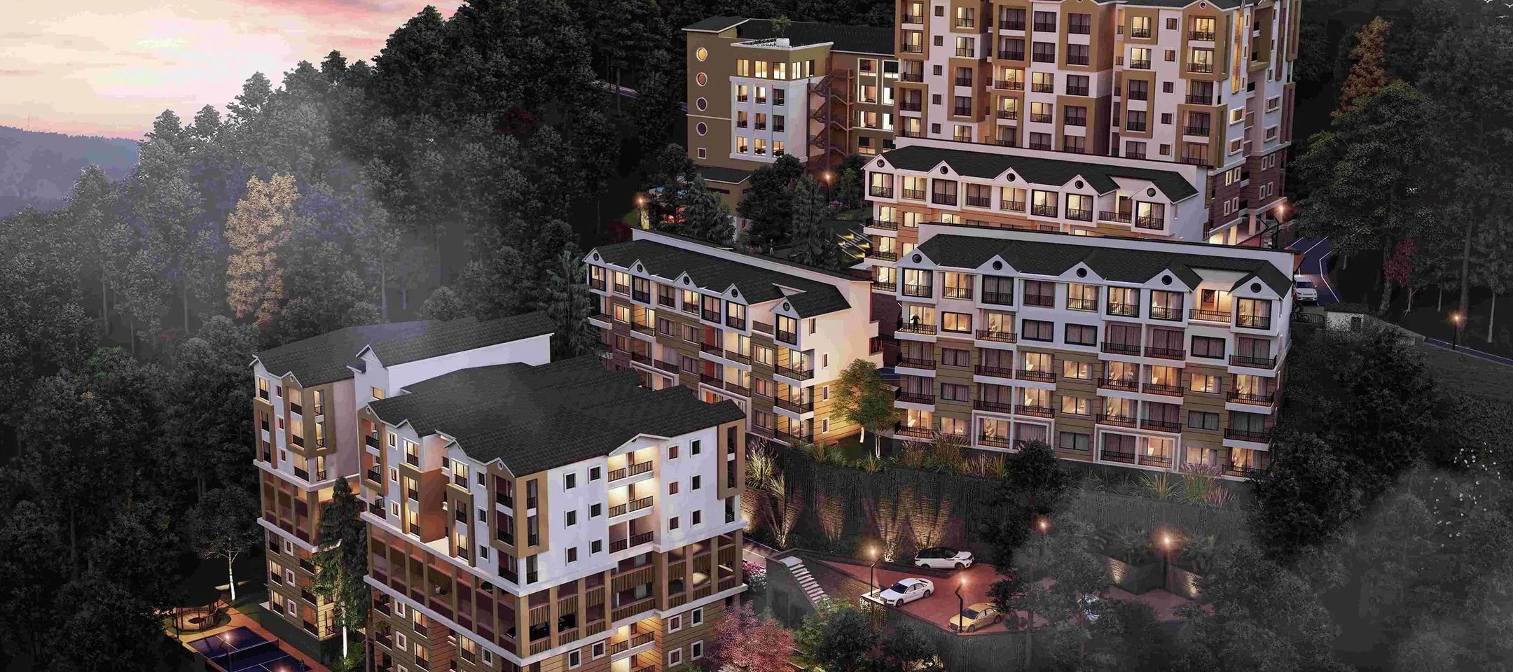 The whole site at dusk, the blocks lit down the slope.