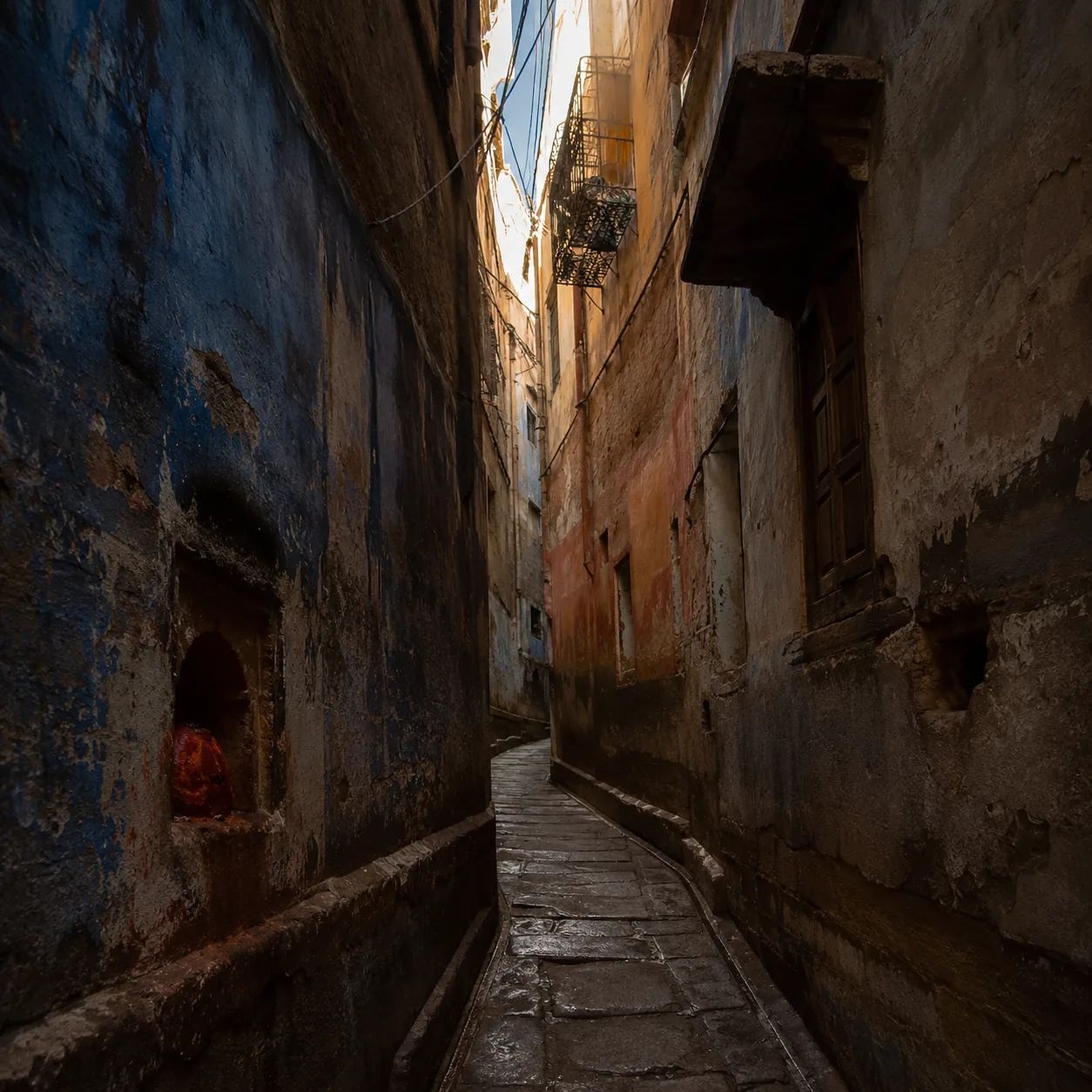 A stone lane in the old city, a shrine set into the wall.